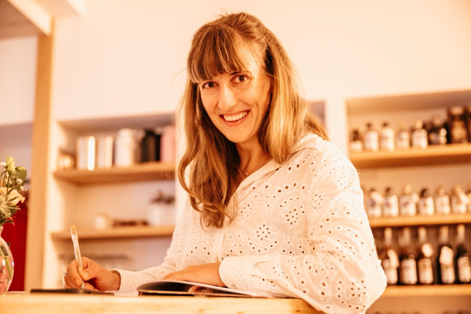 Jule Mohr am Tisch, mit Stift und aufgeschlagenem Heft